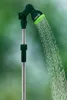 A garden shower with water spraying from the shower head, set against a blurred green background. Produktbild-Vorschau