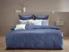 A neatly made bed with blue and white striped bedding. Produktbild-Vorschau