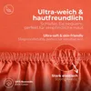 Close-up of an orange fabric with text overlays highlighting product features. Produktbild-Vorschau