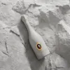 A bottle of wine is placed on a textured, light gray surface that resembles rock or stone. Produktbild-Vorschau