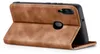A brown leather flip case for a smartphone is shown standing open, revealing the phone inside. Produktbild-Vorschau