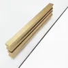 A close-up, angled shot of a brushed gold shower door handle on a white surface, with a thin black line suggesting a glass edge. Náhľad obrázku produktu