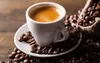 A close-up shot of a white cup of espresso coffee surrounded by coffee beans, with a burlap sack of coffee beans in the background. Podgląd zdjęcia produktu
