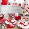 A festive Christmas table setting with red and white decorations, including Santa Claus themed placemats and crackers. Produktbild-Vorschau