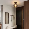 A hallway with a ceiling light, mirror, bench, and door. Produktbild-Vorschau