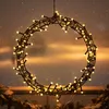 A circular wreath decorated with small LED lights, hanging outdoors in what appears to be snowy weather. Anteprima dell’immagine prodotto