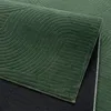Close-up view of a green rug with a geometric arc pattern. Podgląd zdjęcia produktu