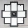 The back of a black photo frame clock with white photo inserts against a textured gray wall. Produktbild-Vorschau