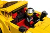 A LEGO minifigure driver wearing a racing suit and helmet sits in the cockpit of a yellow LEGO car. Náhled obrázku produktu