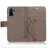 A gray flip case for a smartphone, featuring a floral and butterfly embossed design. Produktbild-Vorschau