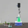 A laboratory setup with a magnetic stirrer and various glassware containing green and blue liquids. Náhled obrázku produktu