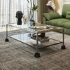 A modern living room with a glass coffee table and a green sofa. Produktbild-Vorschau