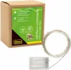 A cardboard box with product information and a coiled string of LED lights and a battery pack next to it. Produktbild-Vorschau