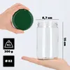 A hand holds a green lid above a clear glass jar, with dimensions and weight indicated by text and icons. Podgląd zdjęcia produktu