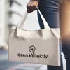 A person is holding a tote bag with a logo and text on it. Produktbild-Vorschau