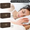 A woman sleeping in bed, with three digital alarm clocks displayed in the foreground. Anteprima dell’immagine prodotto