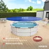 A round pool cover is shown over a round pool on a wooden deck, with a house and garden in the background. Produktbild-Vorschau