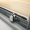 A close-up view of a shower door track and roller mechanism, with a wooden floor in the background. Produktbild-Vorschau