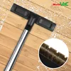 A vacuum cleaner floor nozzle is shown close-up on a wooden floor, with white particles scattered on the floor. A circular inset shows a close-up of the brush bristles. Náhled obrázku produktu