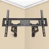 A black TV wall mount is shown mounted on a light beige wall in a corner, with white crown molding at the top. Produktbild-Vorschau