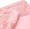 A close-up view of a rolled-up pink yoga mat with a leaf pattern. Podgląd zdjęcia produktu