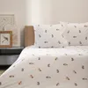 A bedroom scene with a bed made up with patterned bedding and pillows. Podgląd zdjęcia produktu