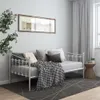 A white metal daybed with pillows and a blanket in a room with light gray walls and white curtains. Produktbild-Vorschau