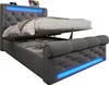 A grey upholstered bed frame with the mattress lifted to reveal storage space underneath. Blue LED lights are visible along the base and headboard. Produktbild-Vorschau