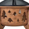 Close-up of a fire pit with a mesh screen and cut-out tree designs. Produktbild-Vorschau