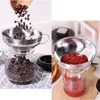 A split image showing a stainless steel funnel being used to fill jars with coffee beans and ketchup. Produktbild-Vorschau