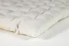 A close-up, angled view of a tufted cushion on a white background. Produktbild-Vorschau