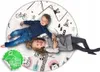 Two children are lying on a round play mat with a woodland-themed pattern. Náhled obrázku produktu