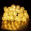 A string of solar-powered LED lights with round, textured bulbs. Voir les images du produit