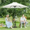 A couple and their dog enjoying a picnic under a large white umbrella in a grassy park. Produktbild-Vorschau