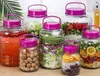 A collection of glass jars filled with various food items and liquids, arranged on a wooden surface. Produktbild-Vorschau