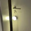 A hexagonal LED light is hanging from a door handle. Produktbild-Vorschau
