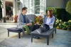 A couple relaxing on sunloungers on a patio. Produktbild-Vorschau