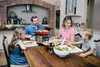 A family enjoying a meal together at a dining table. Podgląd zdjęcia produktu