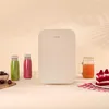 A mini-refrigerator is displayed on a table with drinks and cake. Anteprima dell’immagine prodotto