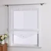 A white sheer Roman blind with decorative embroidery on the bottom edge is shown hanging on a window. Produktbild-Vorschau
