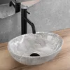 A close-up shot of a grey oval countertop sink with a black faucet. Podgląd zdjęcia produktu