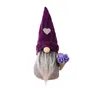A gnome decoration with a purple hat and a bouquet of purple flowers. Produktbild-Vorschau