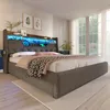 A bedroom scene featuring a modern upholstered bed with integrated LED lighting and storage. Produktbild-Vorschau