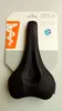 A black bicycle saddle is displayed on its retail packaging. Produktbild-Vorschau