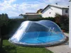 A round swimming pool covered by a clear, dome-shaped enclosure in a backyard setting. Náhled obrázku produktu