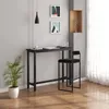 A modern interior scene featuring a black bar table and a black bar stool, with a potted plant and abstract art on the wall. Produktbild-Vorschau