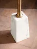 A close-up view of the base of a table, showing the marble pedestal and a portion of the metal leg. Podgląd zdjęcia produktu