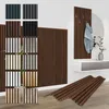 A collection of wood acoustic panels in various colors and finishes, displayed in a modern interior setting with a coat rack and a console table. Produktbild-Vorschau
