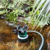 A submersible pump is operating in a pond surrounded by lush green plants. Anteprima dell’immagine prodotto