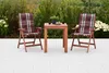 A patio set with two chairs and a table on a paved patio, surrounded by greenery. Produktbild-Vorschau